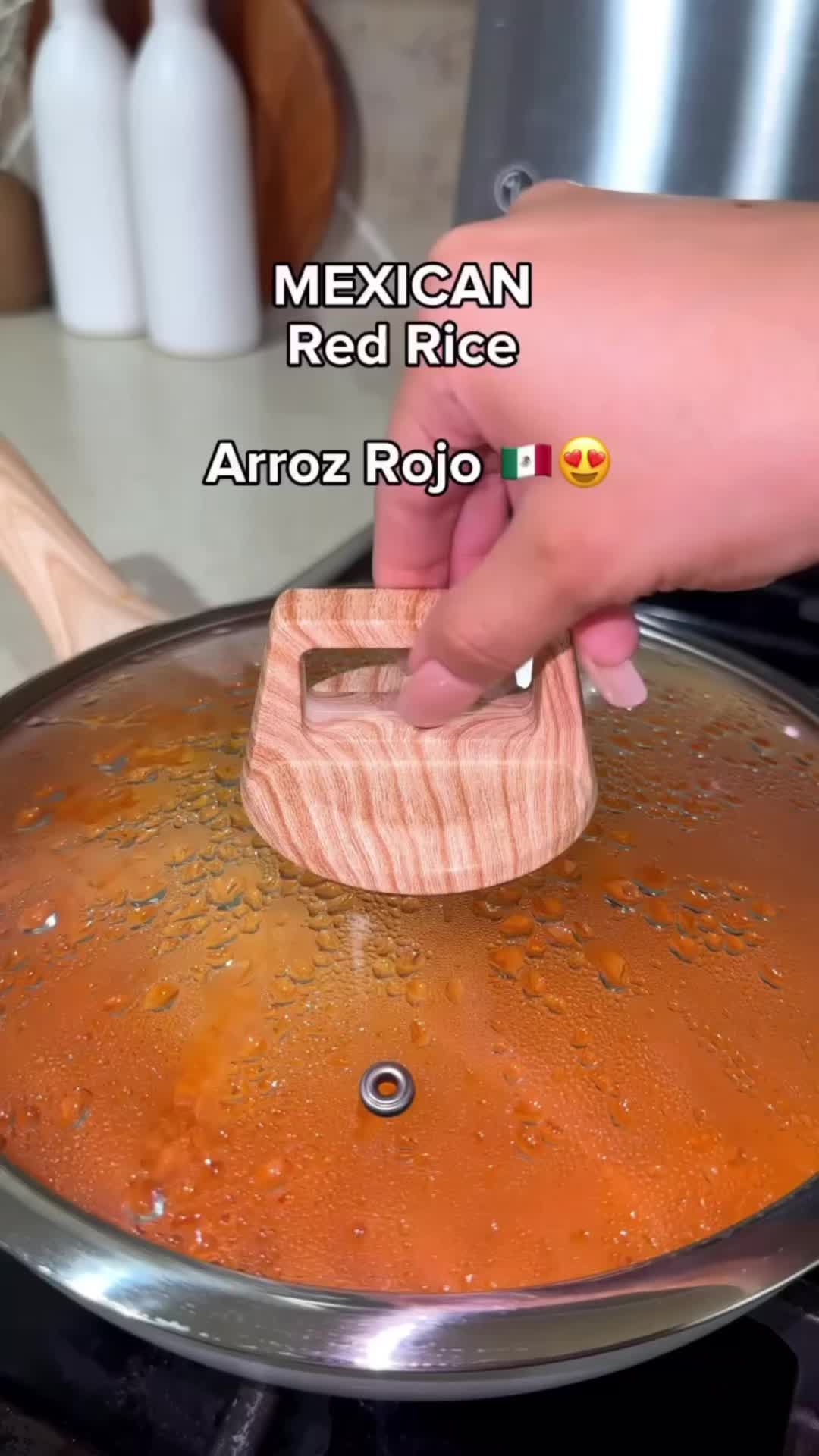 This may contain: two wooden spoons are being used to stir rice in a pan on the stove