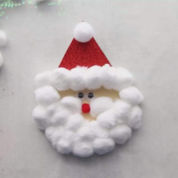 This may contain: someone is making a santa clause ornament out of toilet paper and cotton balls