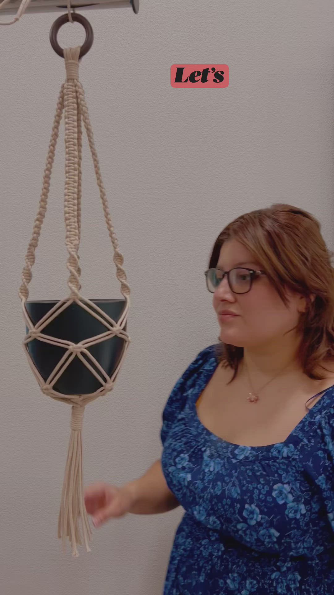 This may contain: a woman in glasses holding up a macrame