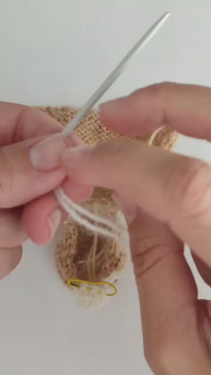 This may contain: two hands are working with yarn and scissors to make stuffed sheeps on the table