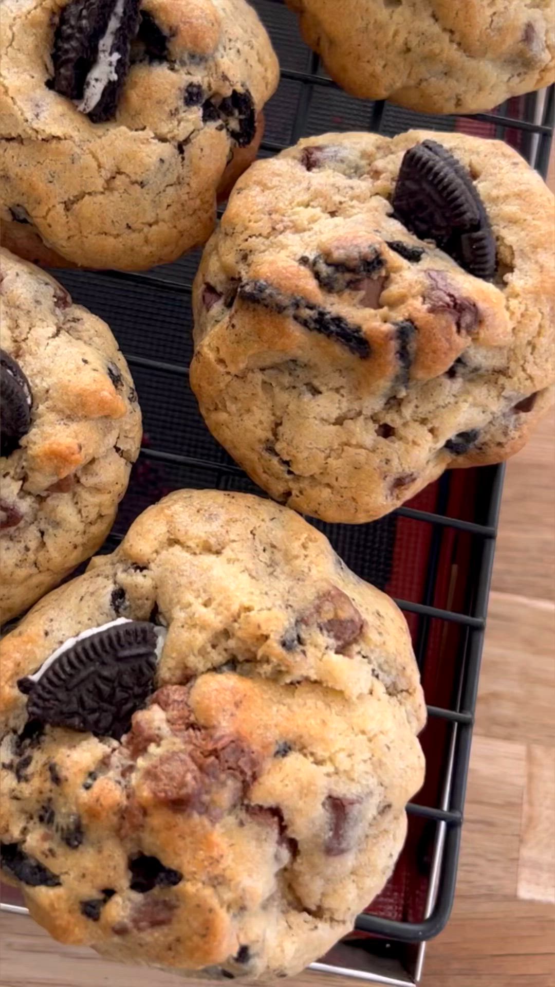 This may contain: chocolate chip cookies cooling on a rack with oreos in the middle and one cookie missing