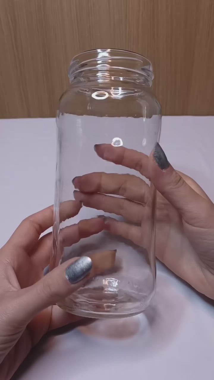 This may contain: two hands holding something in a glass jar