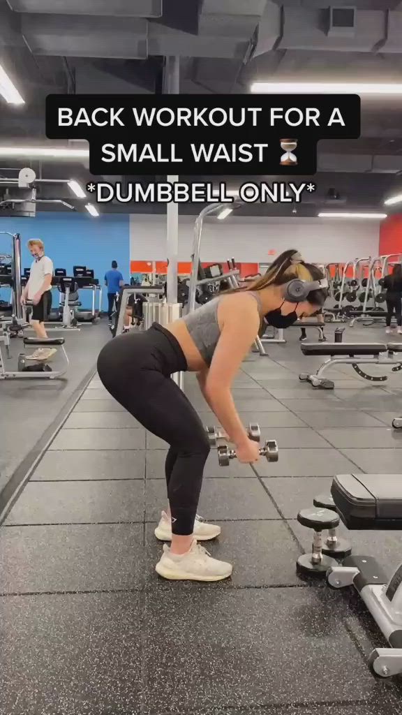 This may contain: a woman squatting on a bench in a gym