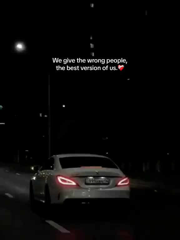 This may contain: a car driving down the road at night with an ad on it's side