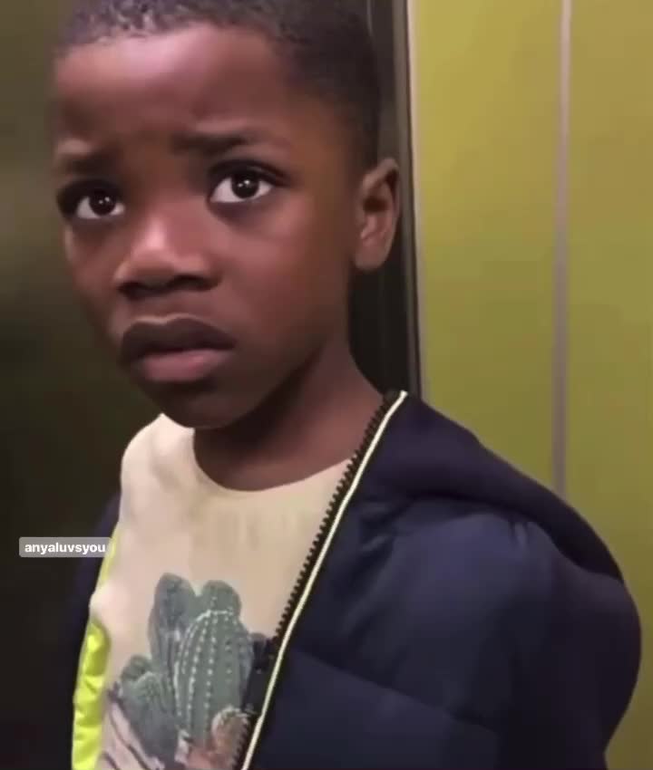 This may contain: a young boy is standing in front of a mirror and looking at the camera with an intense look on his face