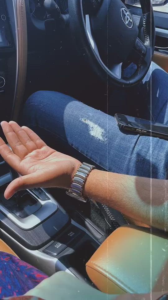 This may contain: a person's hand on the steering wheel of a car with their palm up