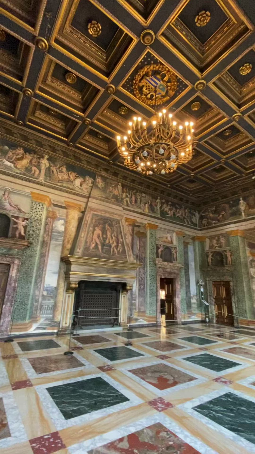 This may contain: an ornately decorated room with chandeliers and paintings on the walls