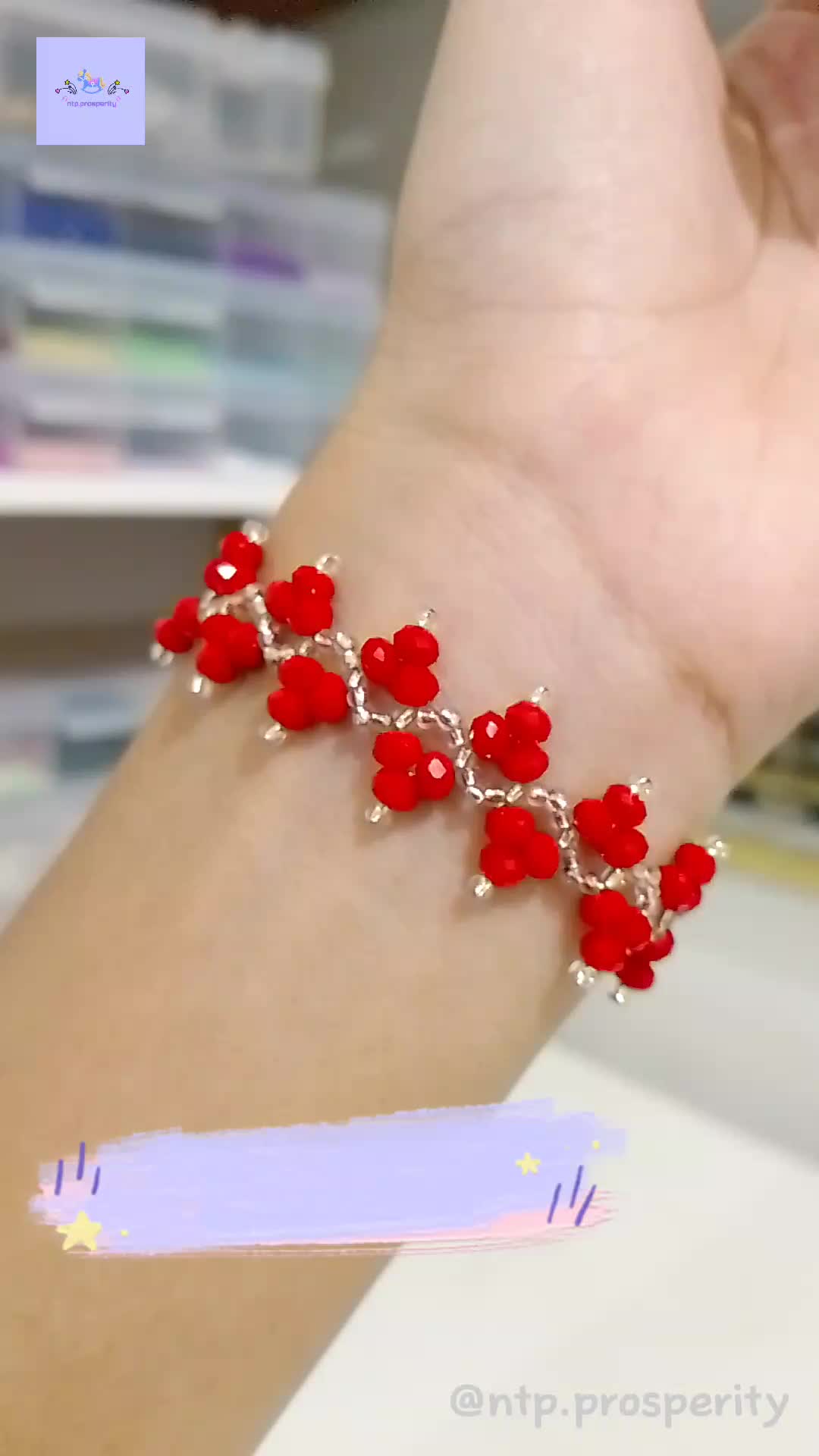 This may contain: a woman's arm with red beads on it