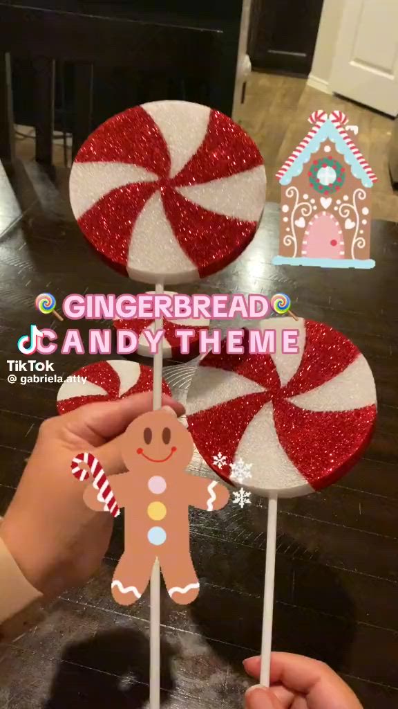 This may contain: someone is holding up two lollipops with gingerbread on them, and the top one has a gingerbread