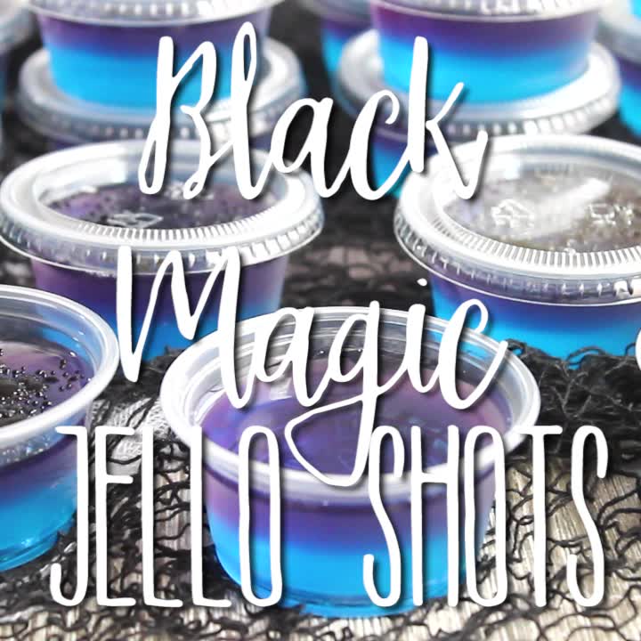 This may contain: black magic jello shots in plastic cups with the words, black magic jello shots