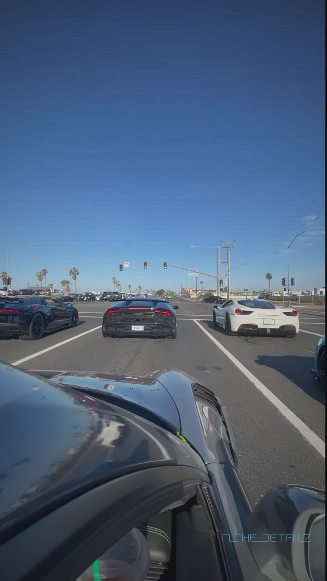 This may contain: cars are driving down the highway on a sunny day with palm trees in the background