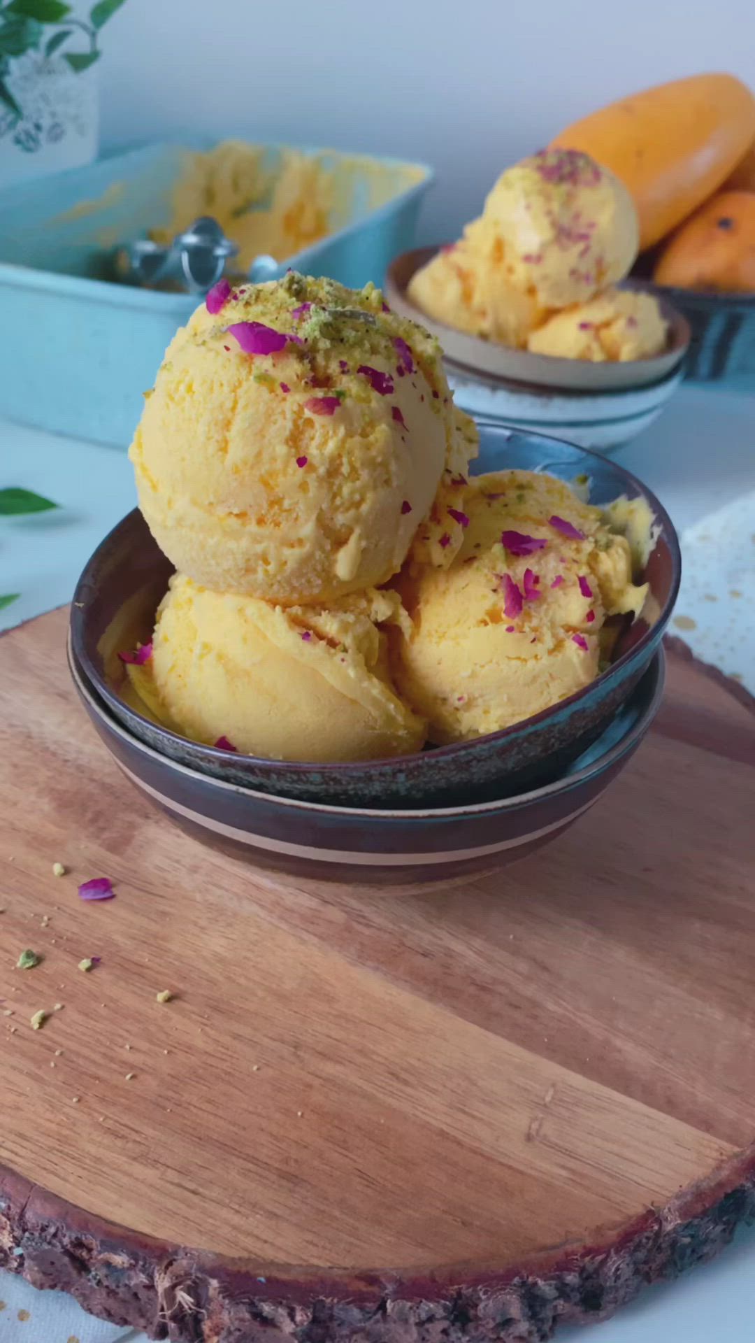 This may contain: three scoops of ice cream in a bowl on top of a wooden cutting board