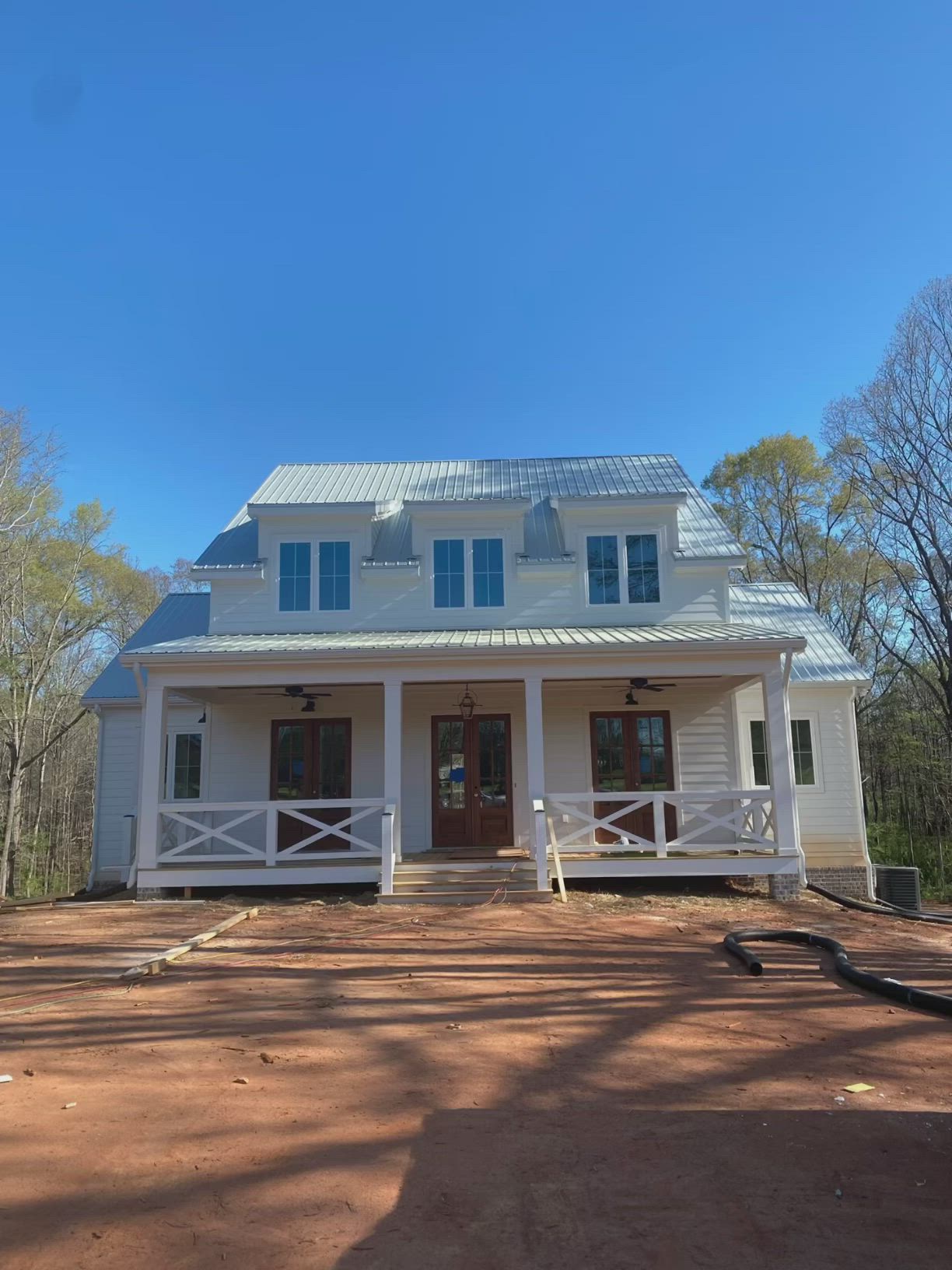 This may contain: a white house sitting on top of a dirt field