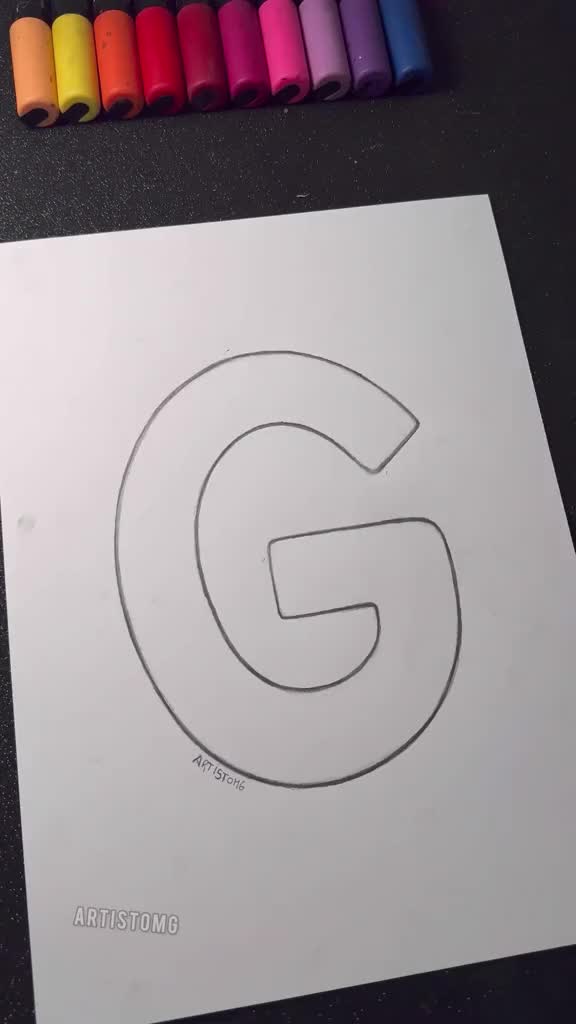 This may contain: the letter g is drawn on paper with crayons next to it and markers