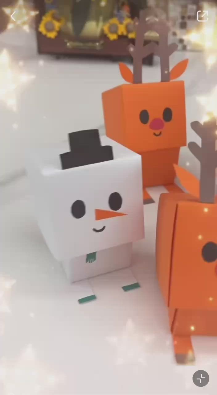 This may contain: three orange and white boxes with faces made out of paper, sitting on a table