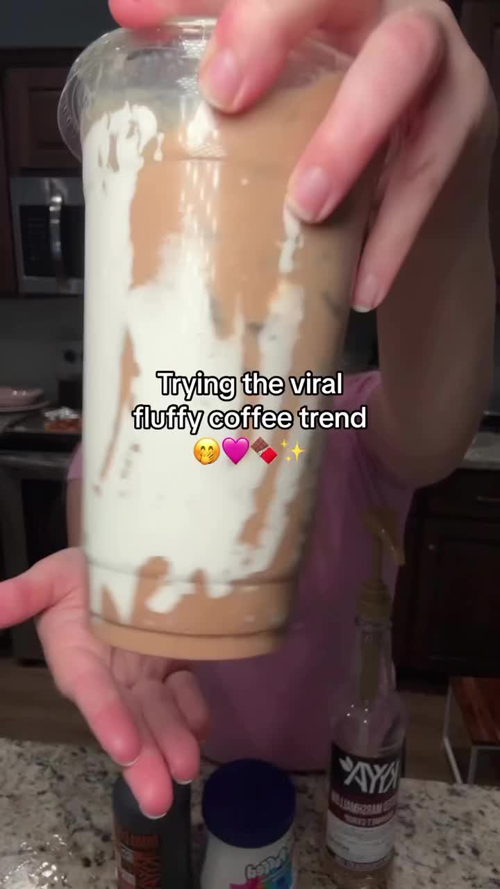 This may contain: someone is holding up a cup with whipped cream on it and the caption says, i'm trying the virtual funny coffee trend