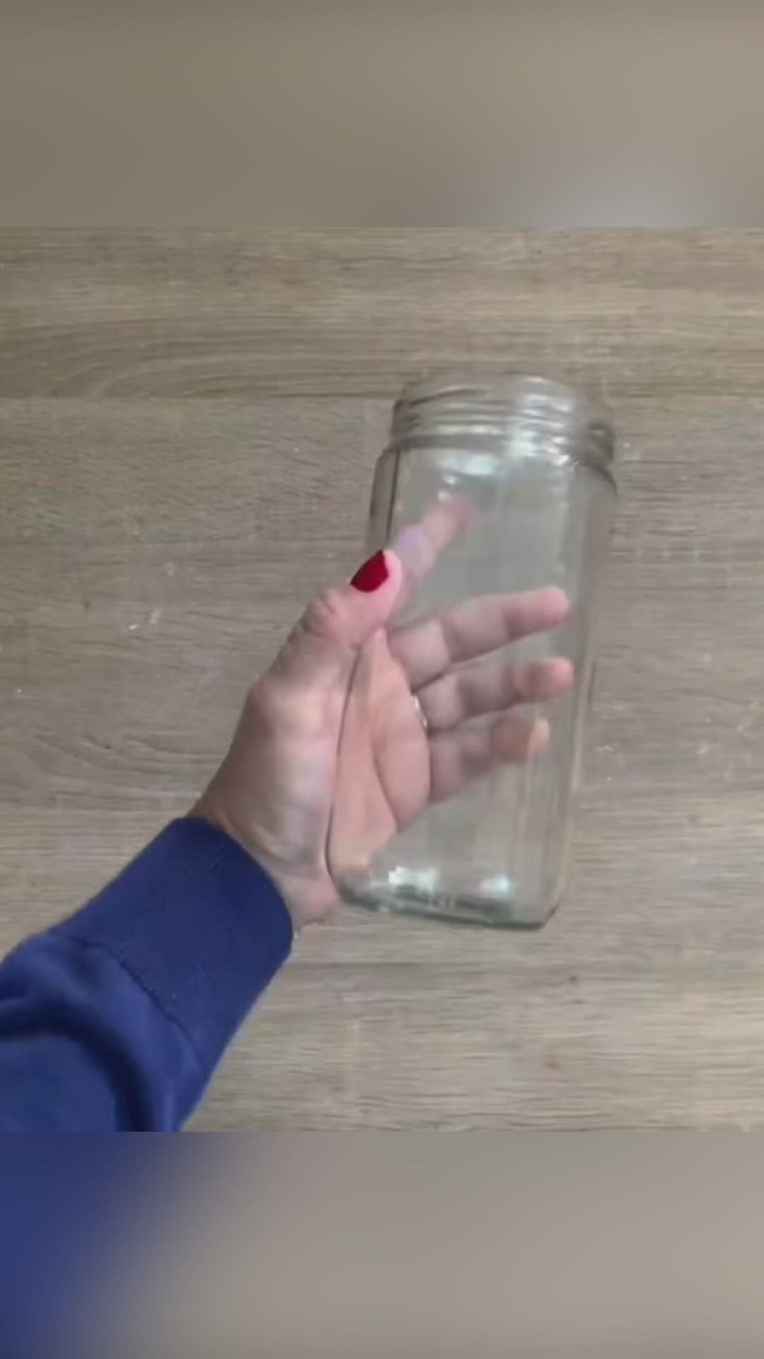 This may contain: a person holding their hand up to a jar