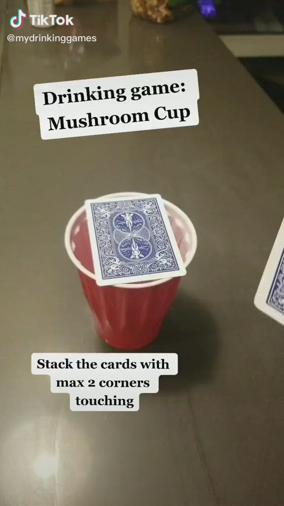 This may contain: a cup with some cards in it sitting on a table next to a card game