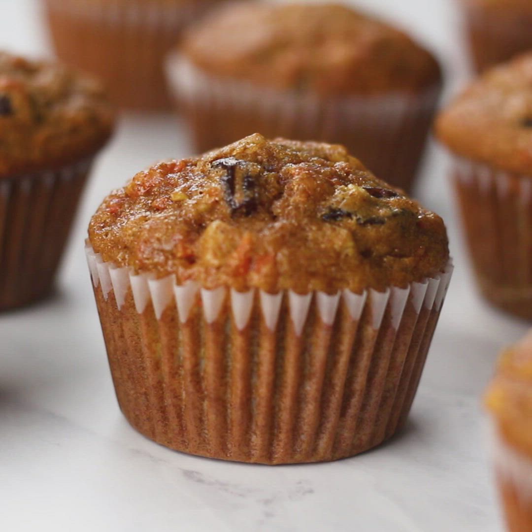 This may contain: a muffin with carrots and raisins in it sitting on a counter