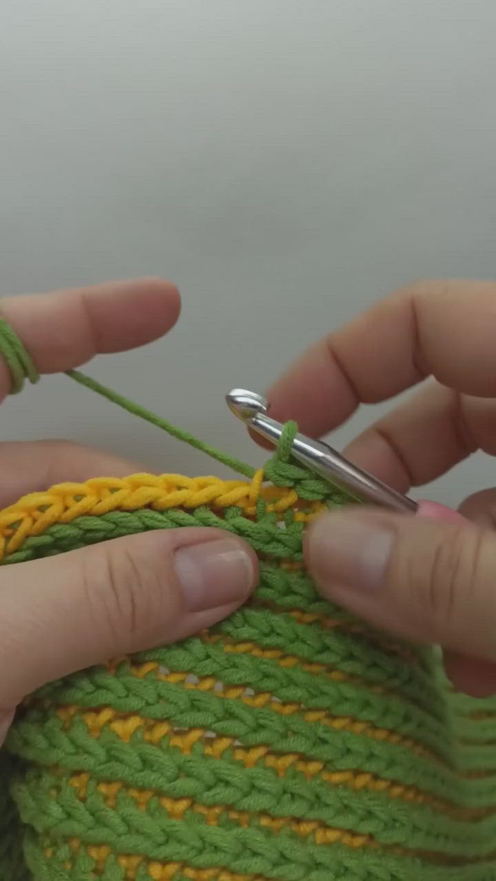 This may contain: someone crocheting the end of a piece of yarn