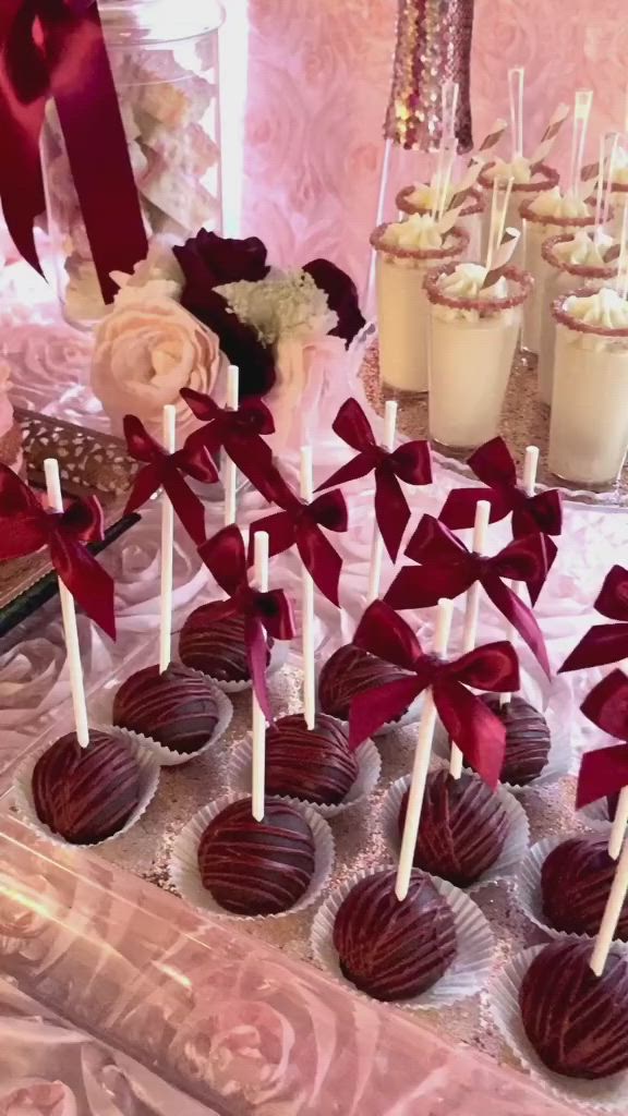 This contains: Beautiful cupcakes and gorgeous sugar cookies stacked with buttercream and topped with sugar flowers. Cupcakes and cake pops and stunning rose gold sugar edged panna cotta parfait cups: