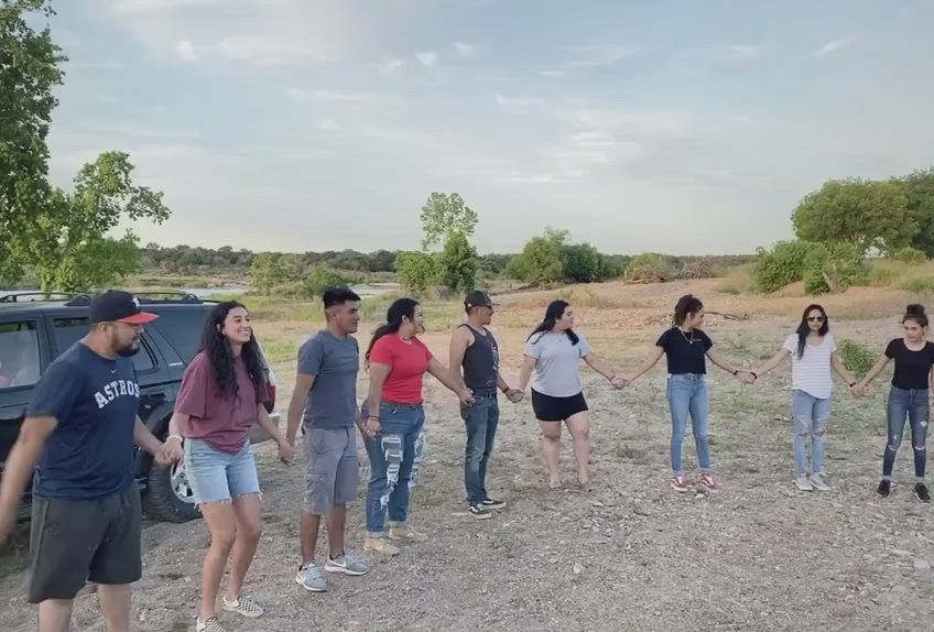 This may contain: a group of people standing in front of a car