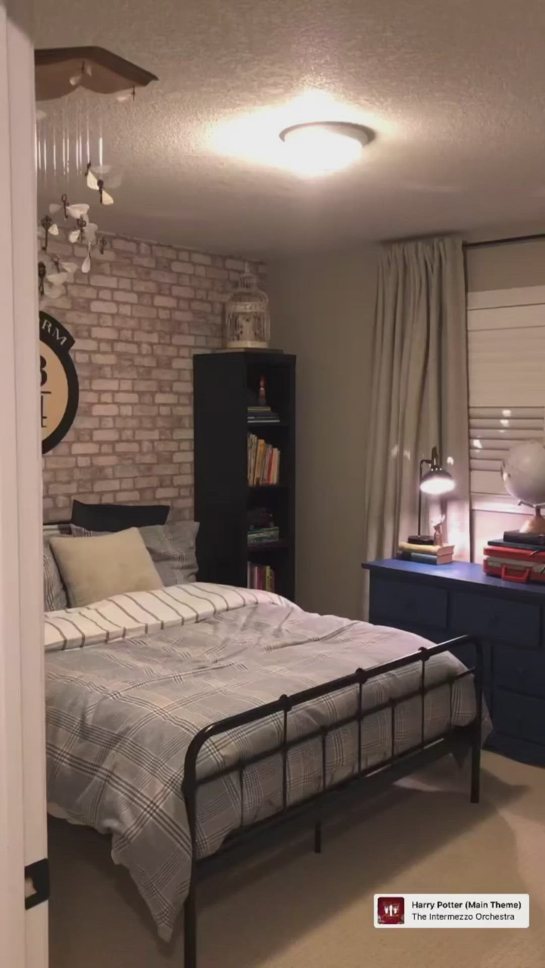 This may contain: a bedroom with a bed, dresser and bookshelf next to a brick wall