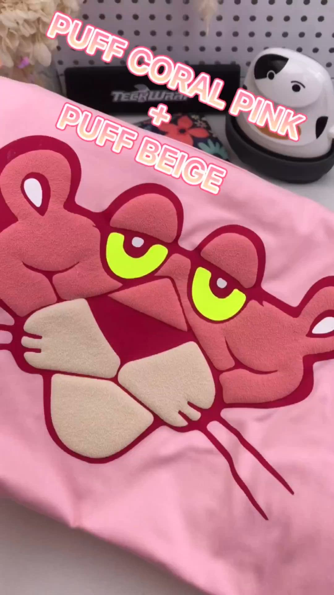 This may contain: a pink shirt with an image of a cat's face on it and the words puff coral pink