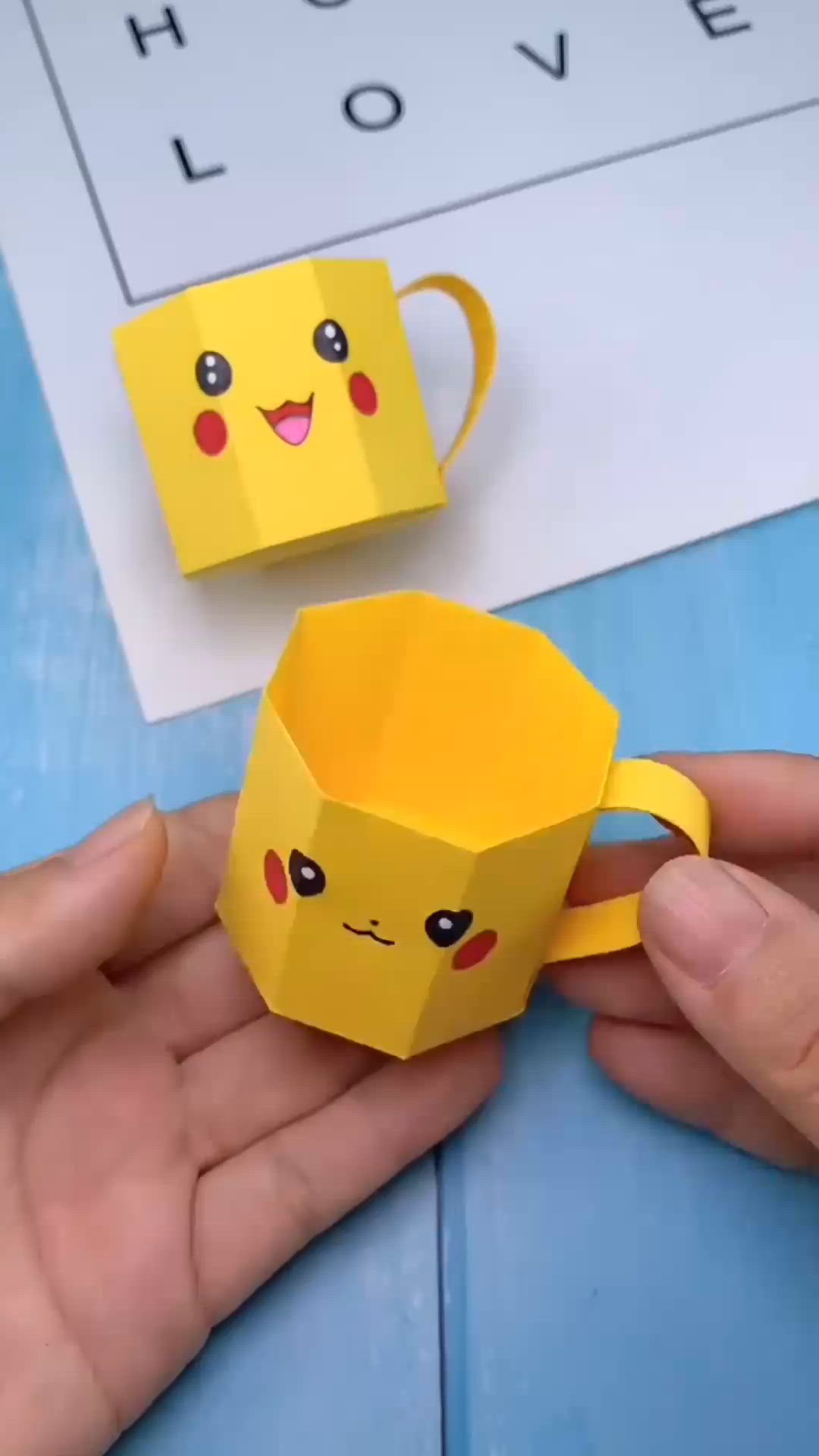 This may contain: someone is holding a paper cup in their hand and it looks like pikachu