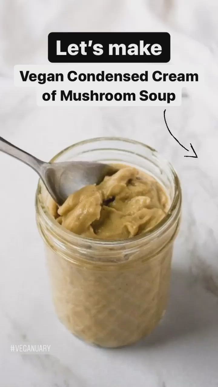 This may contain: a spoon in a jar filled with vegan condensed cream of mushroom soup on a marble counter top