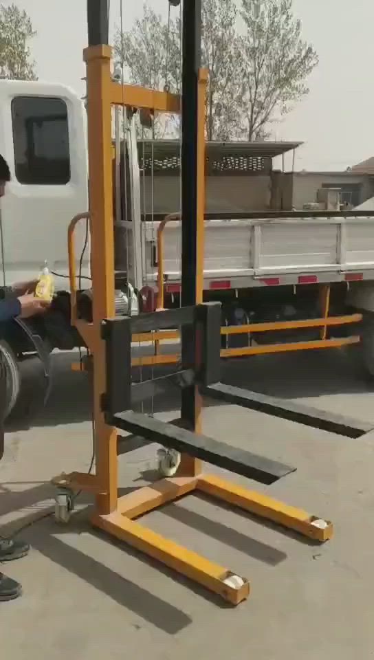 This may contain: a man standing next to a fork lift in front of a white truck on the road