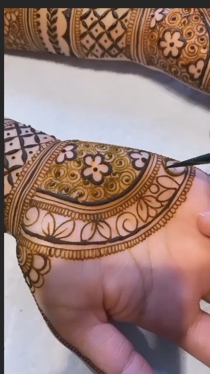 This may contain: someone is doing henna designs on their hands