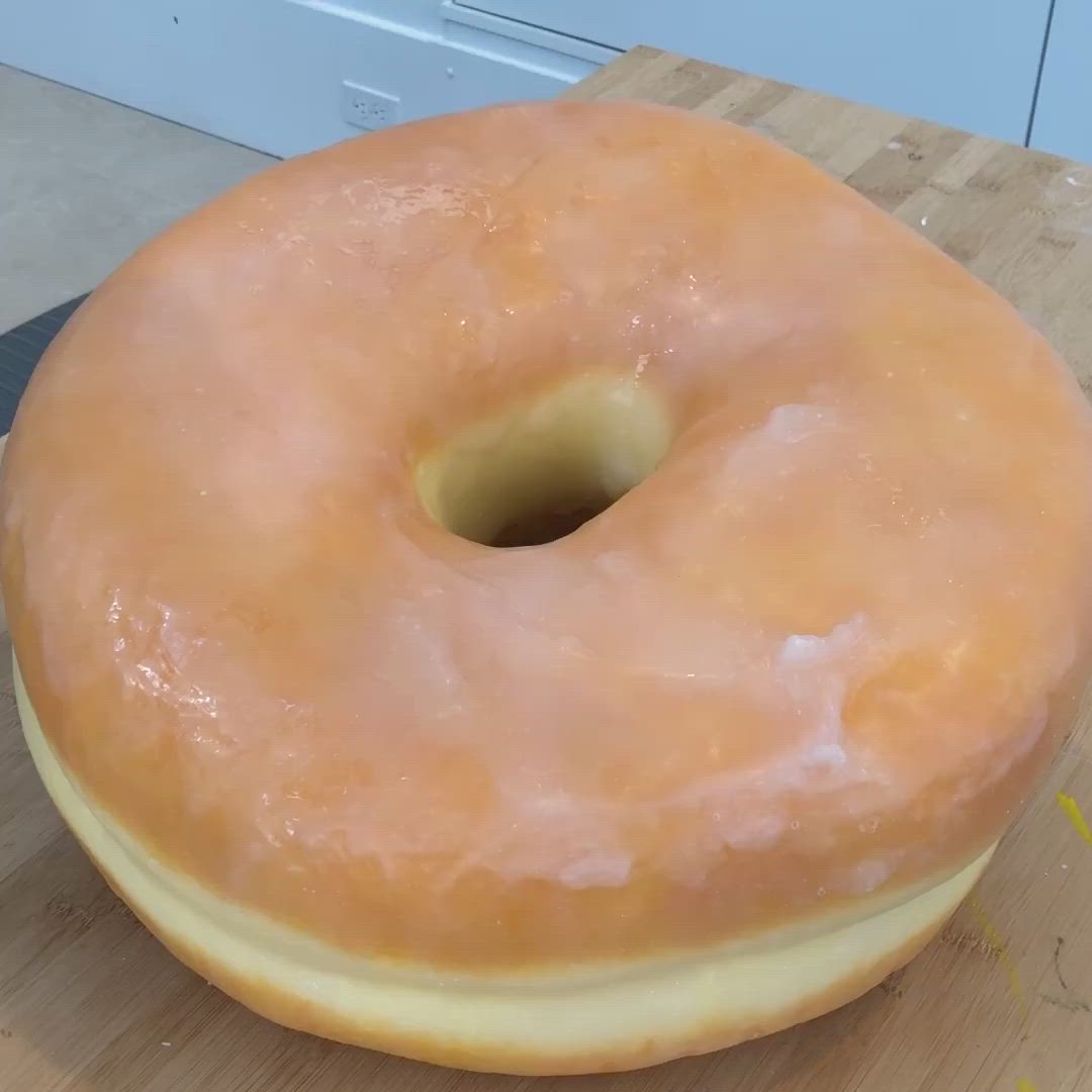 This may contain: a person standing in front of a box of doughnuts