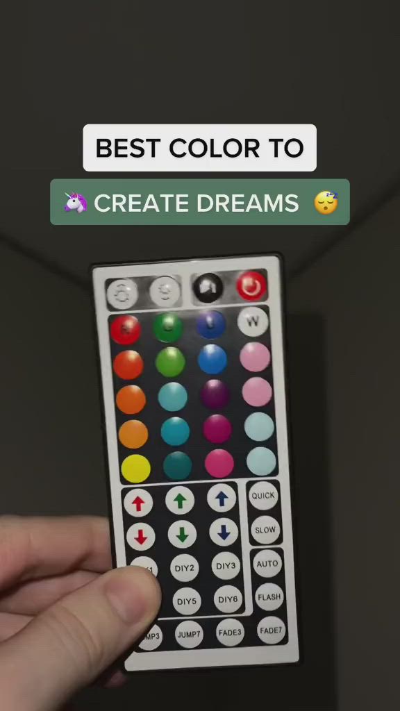 This may contain: a hand holding a remote control with the words best color to create dreams on it