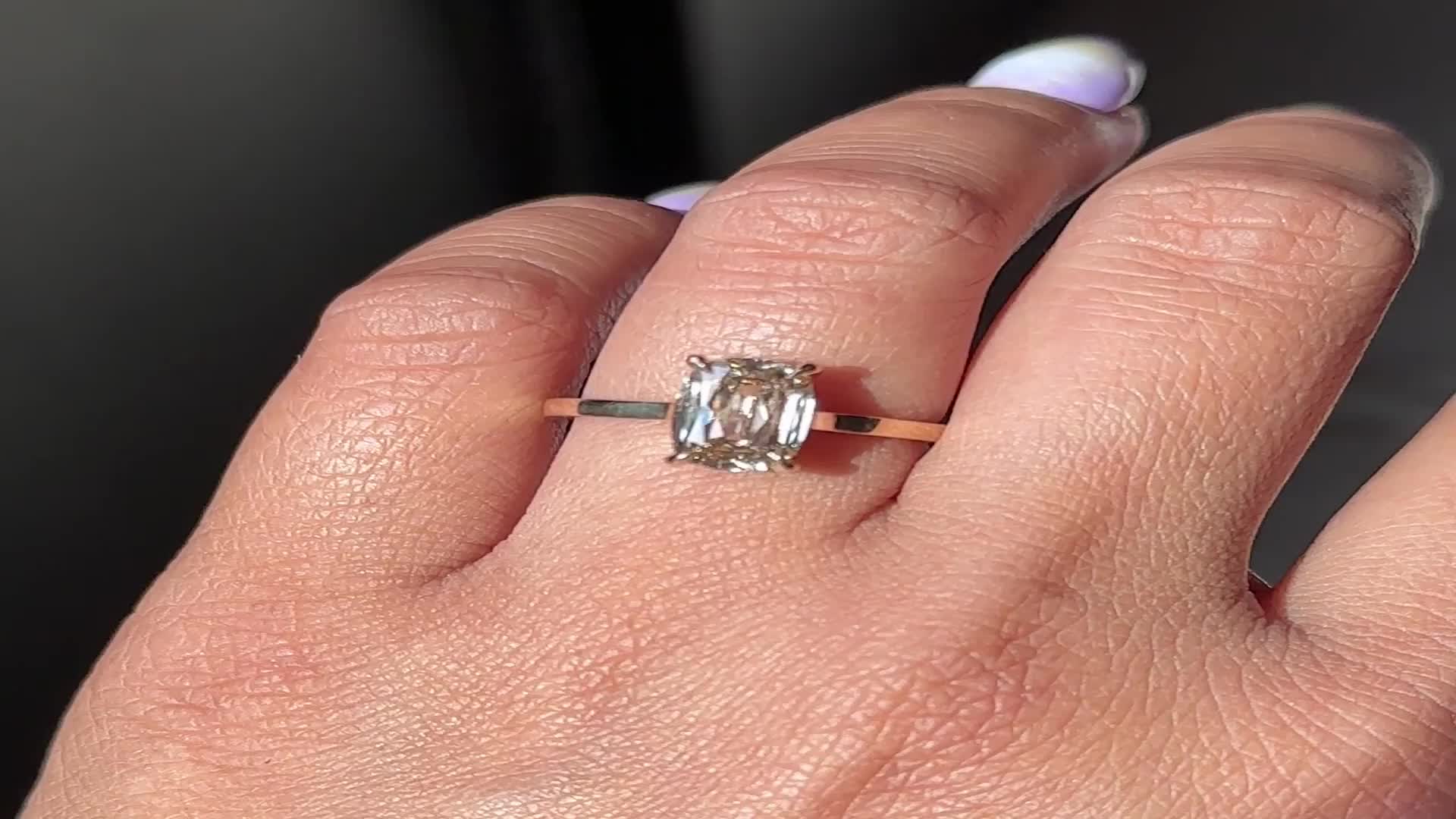 This may contain: a woman's hand with a ring on it and a diamond in the middle