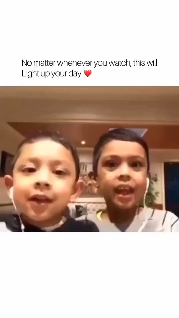 This may contain: two young boys standing next to each other in front of a tv screen with the caption no matter where you watch, this will light up your day