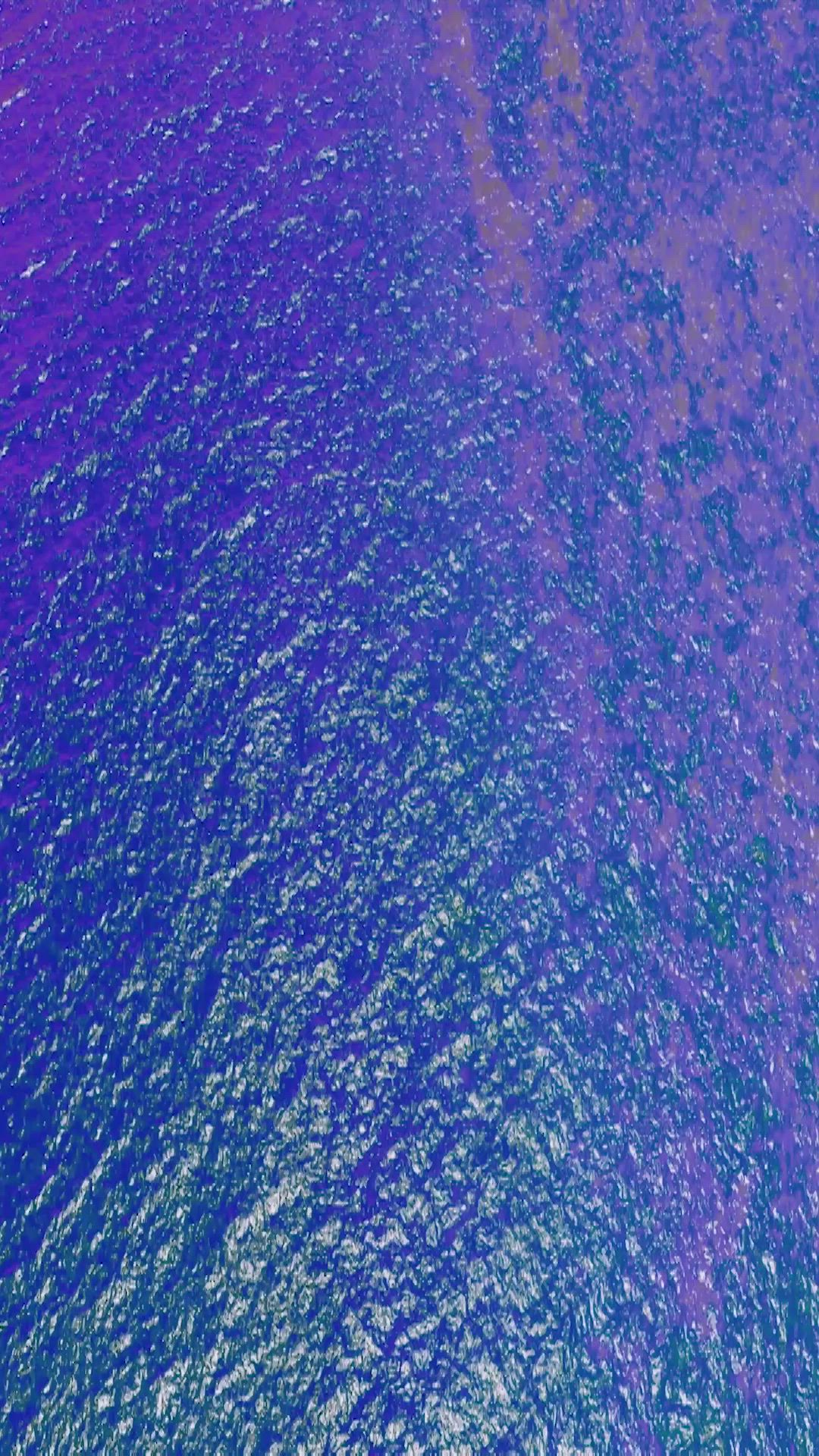 This may contain: an aerial view of the ocean with green and purple colors on it's surface