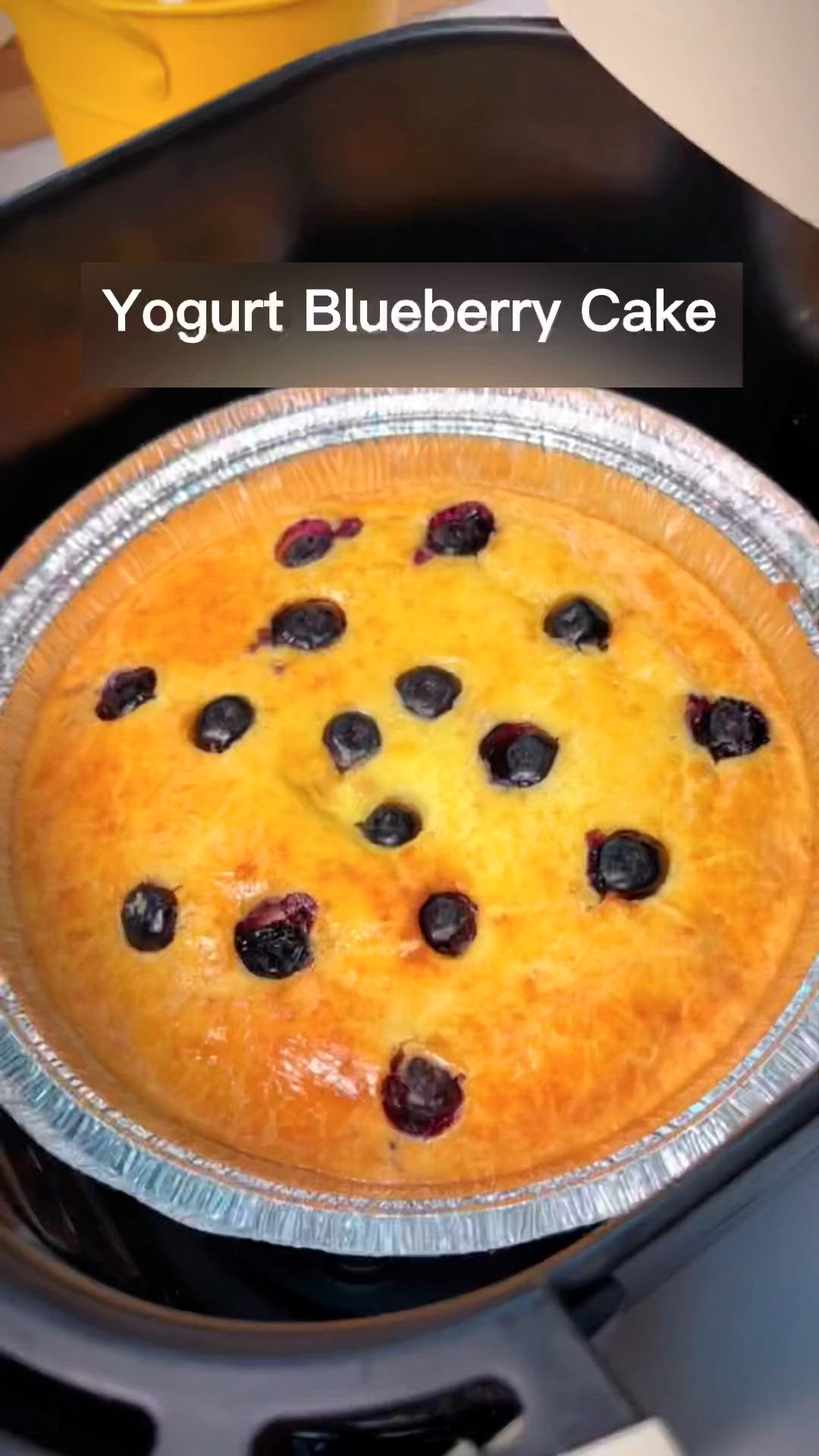 This may contain: a blueberry cake sitting on top of a stove with the words yogurt blueberry cake above it