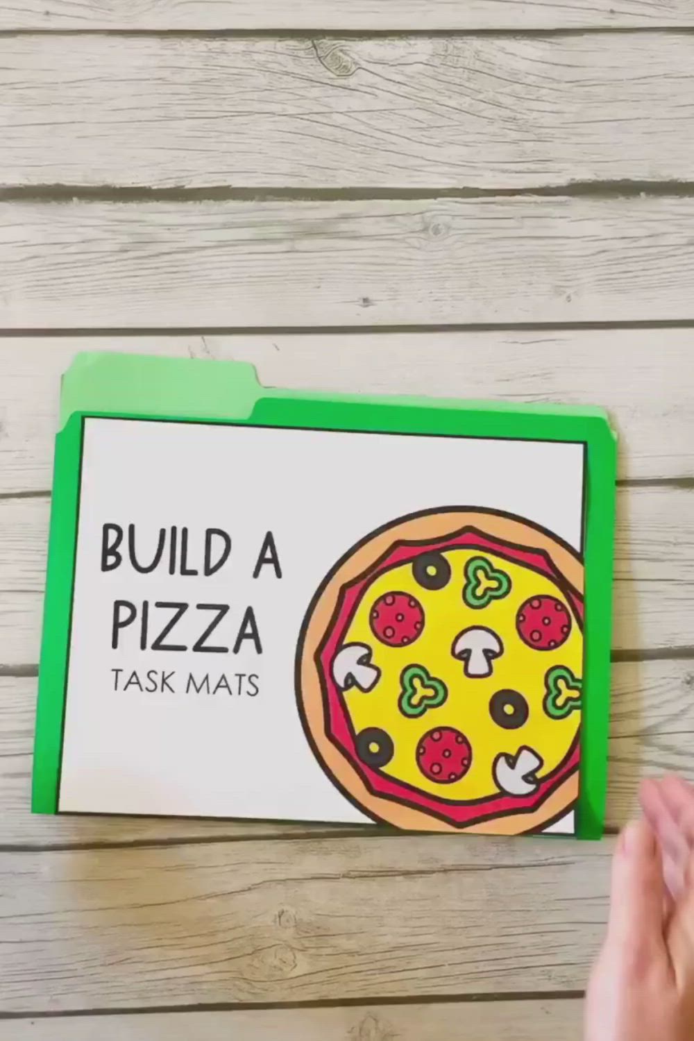 This may contain: the build a pizza task mat is being held up by someone's hand