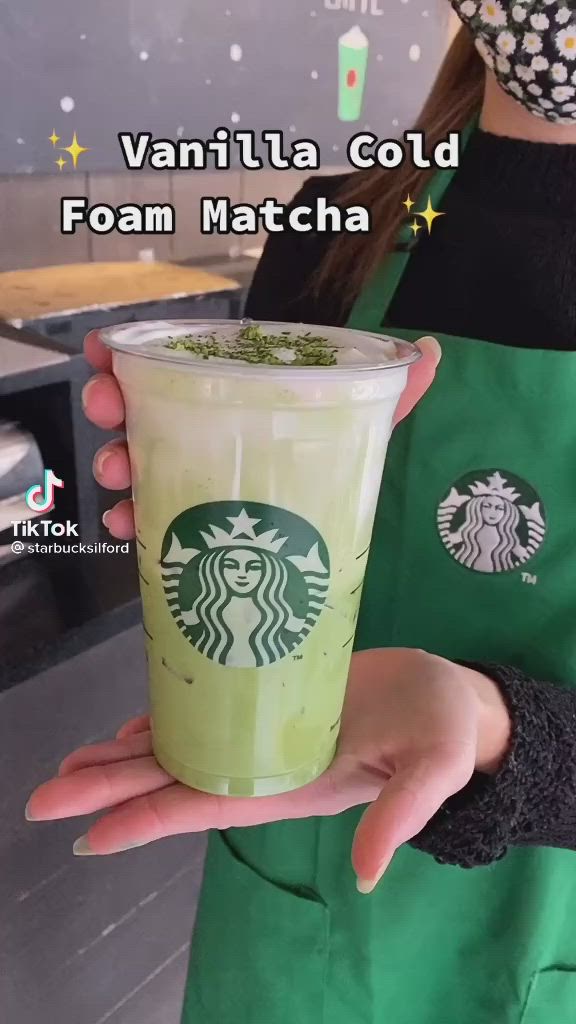 This may contain: a woman holding up a green drink in her hand with the caption vanilla cold foam matcha