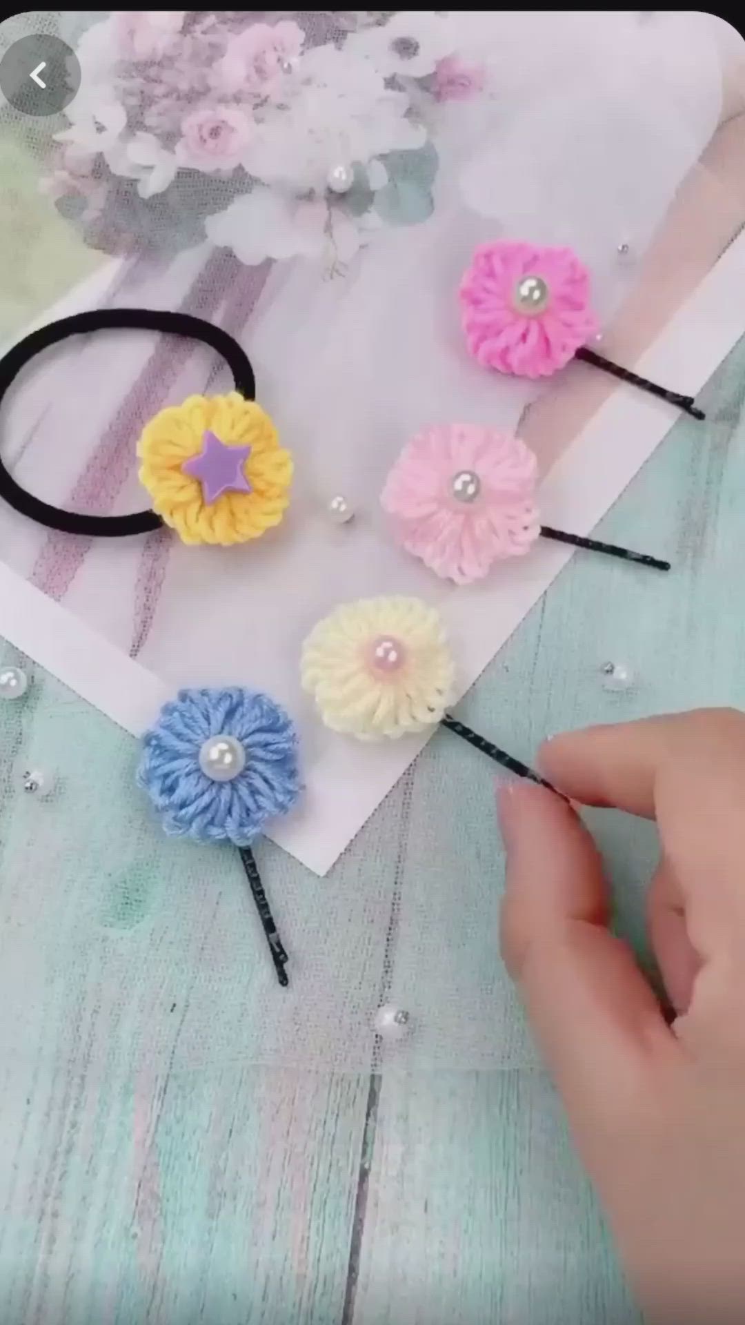 This may contain: two hands are holding small flower hair clips