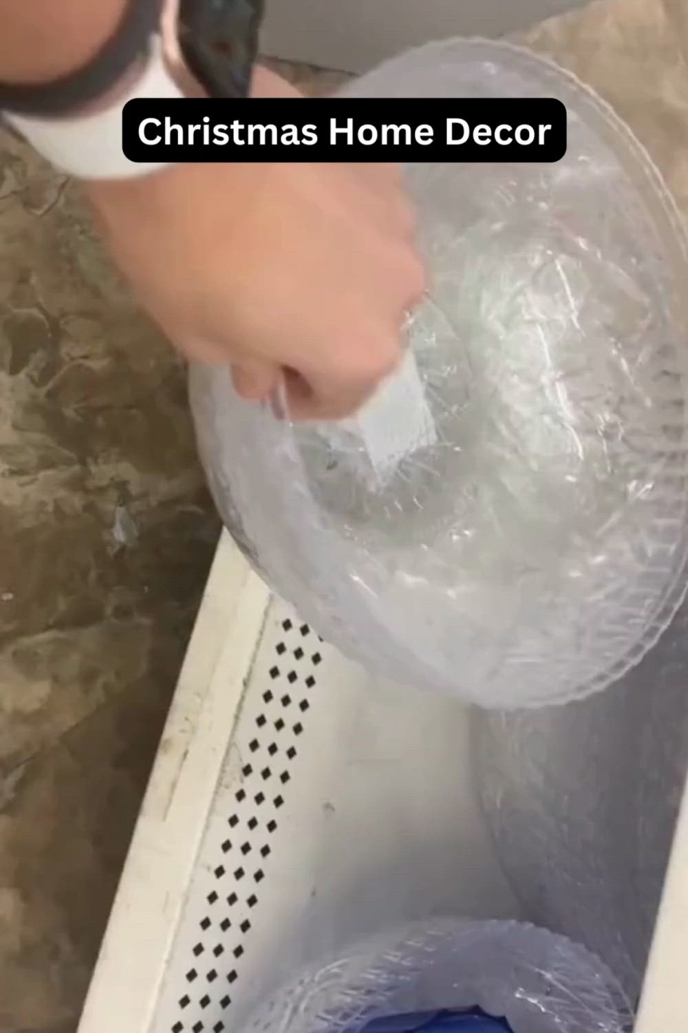 This may contain: a person is using a vacuum to clean a bathtub with plastic wrap around it