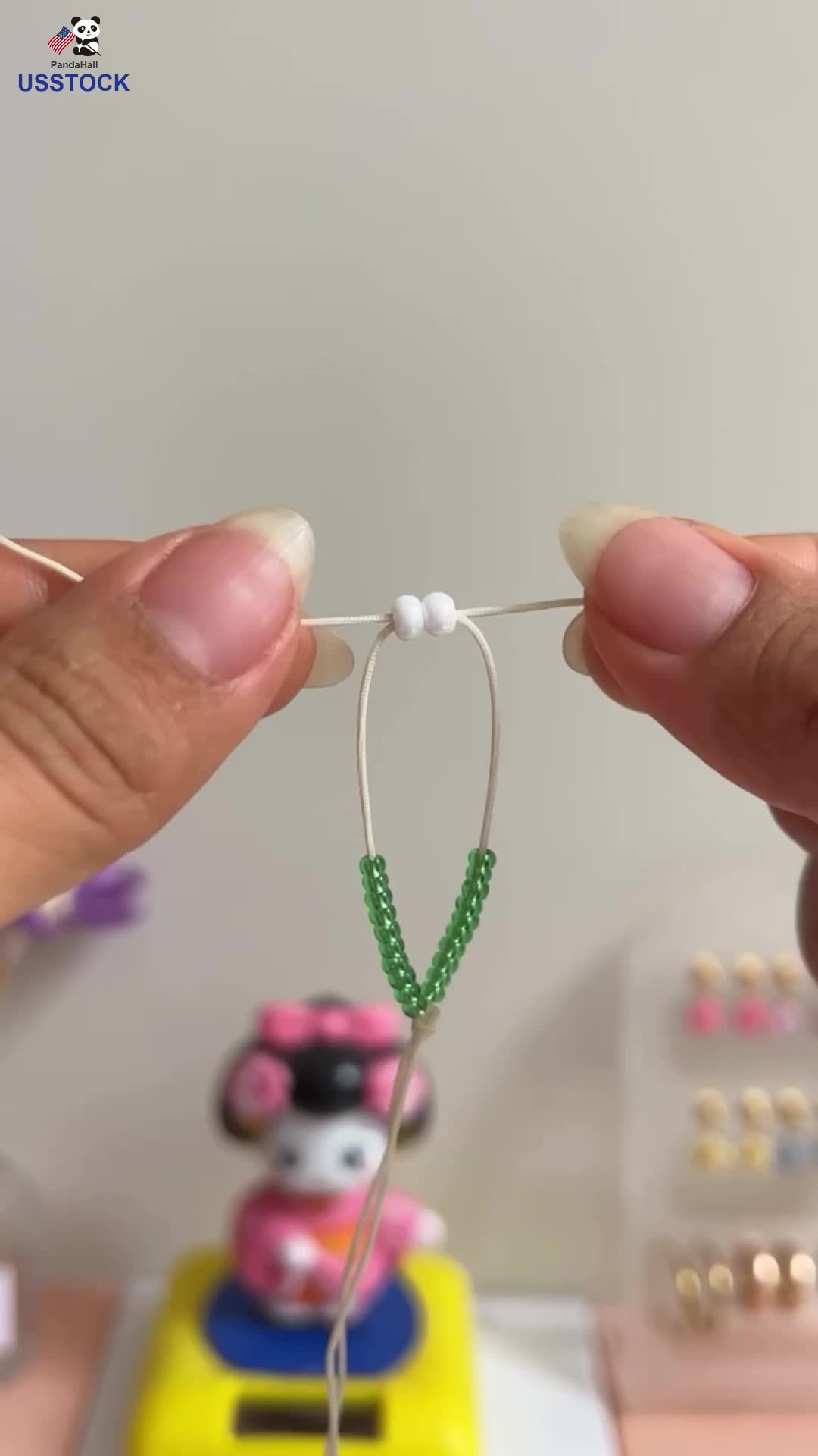 This may contain: someone is stringing the strings to make a mouse car ornament with beads