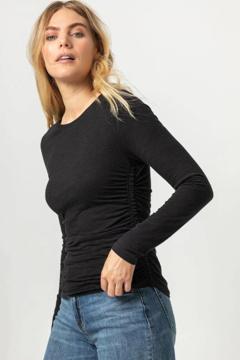 This contains: a woman wearing a black top and jeans