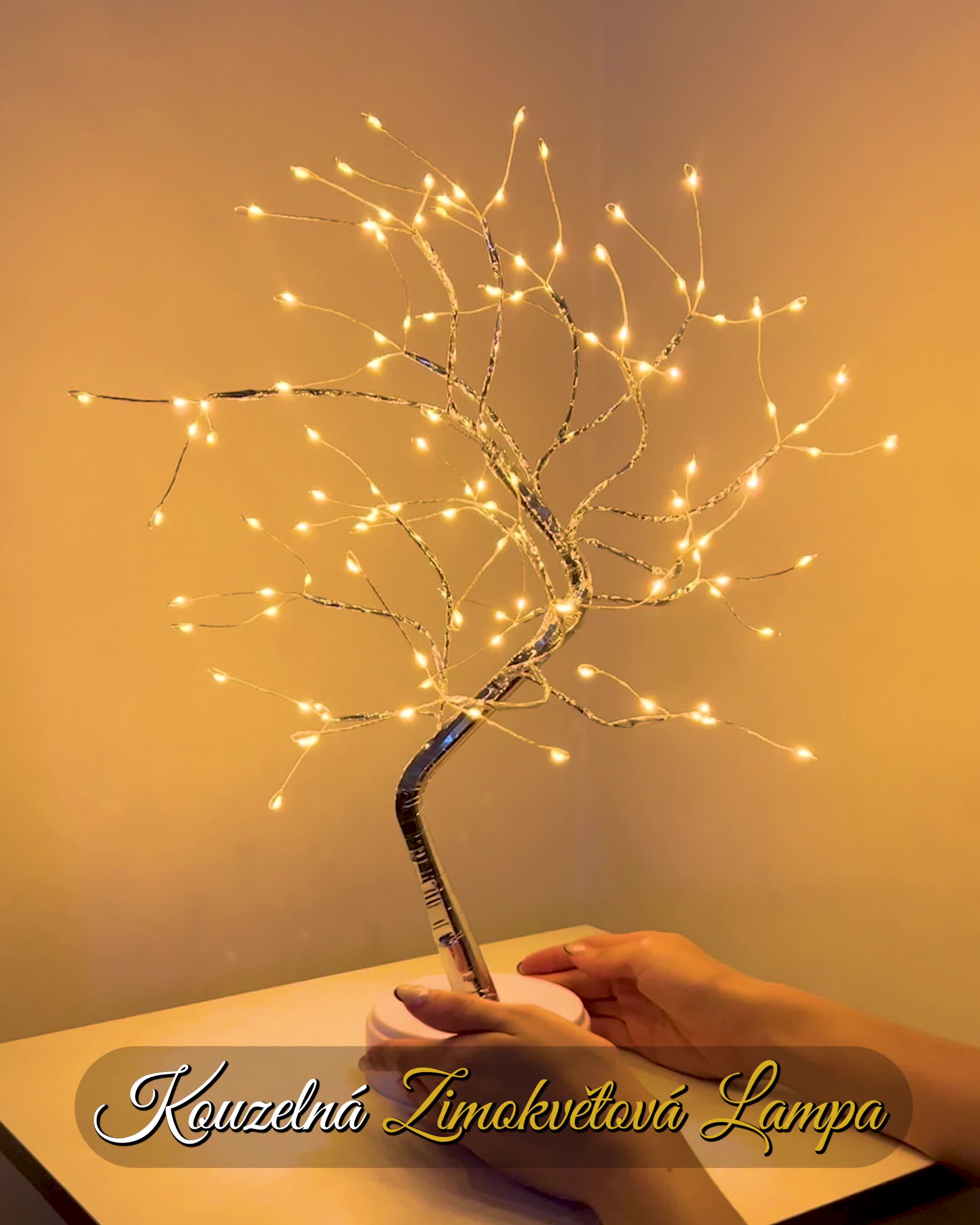 This may contain: a hand holding a lit up tree on top of a table with writing underneath it