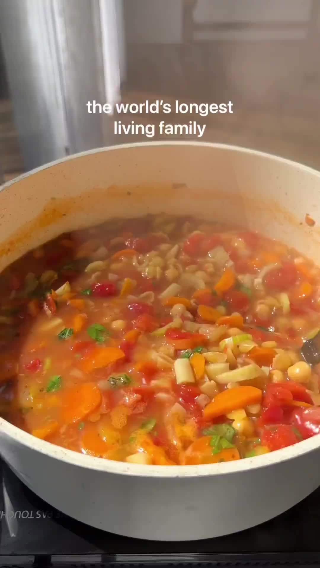 This may contain: a woman is smiling while eating soup from a bowl