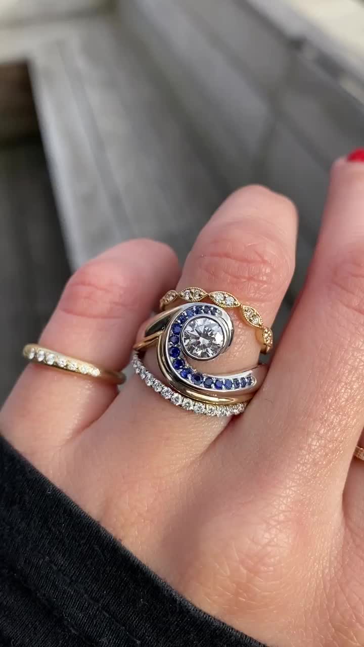 This may contain: a woman's hand with three different rings on it