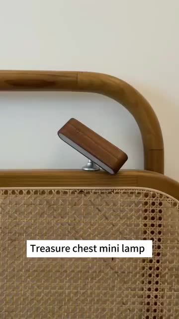 This may contain: there is a brown suitcase with a wooden handle on the top and bottom part, which has a small metal object in it