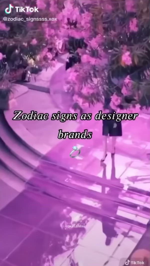 This may contain: a woman standing in front of pink flowers with the words zodiac signs as designer brands