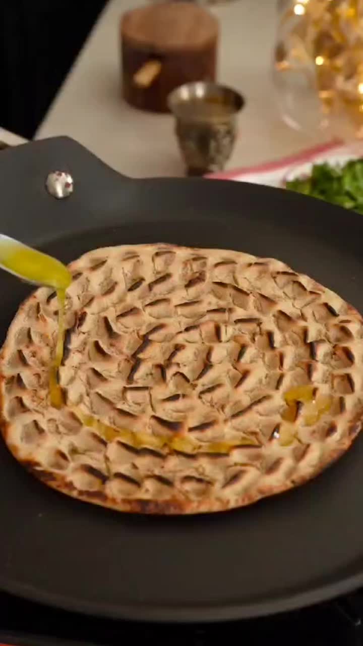 This may contain: a frying pan filled with food on top of a table